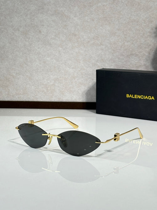 Balenciaga sunglasses with dark tinted lenses and gold-tone metal frame.