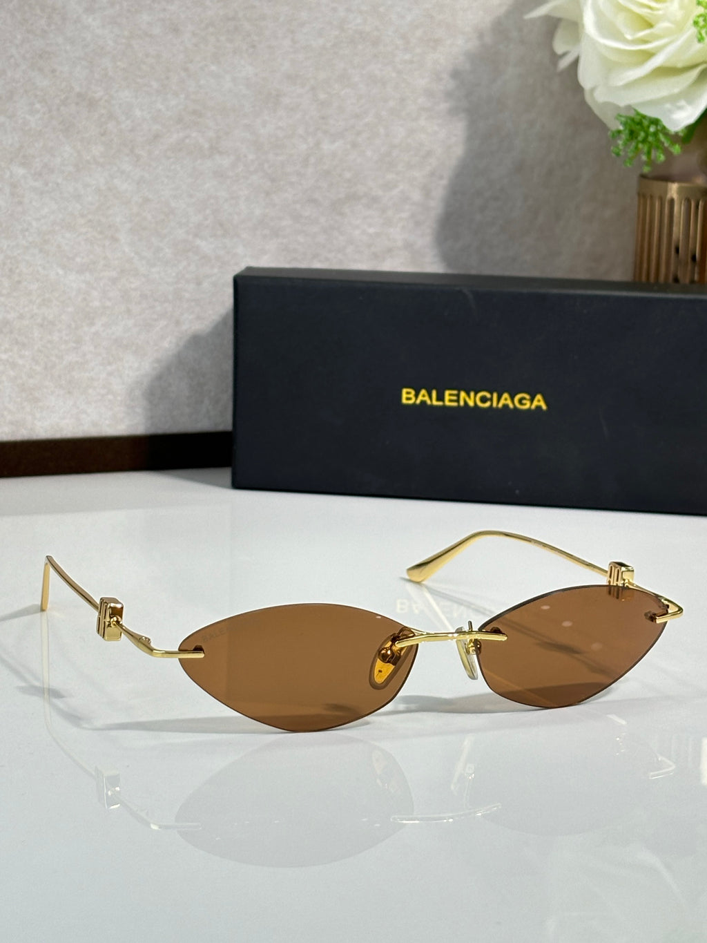 Balenciaga sunglasses with brown lenses and gold-tone metal temple hardware.