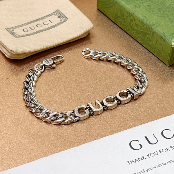 Silver chain bracelet with interlocking links and clasp, on thank-you card