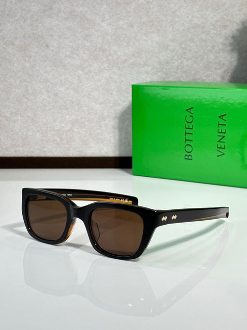 Black sunglasses with dark lenses and gold temple accents, side view