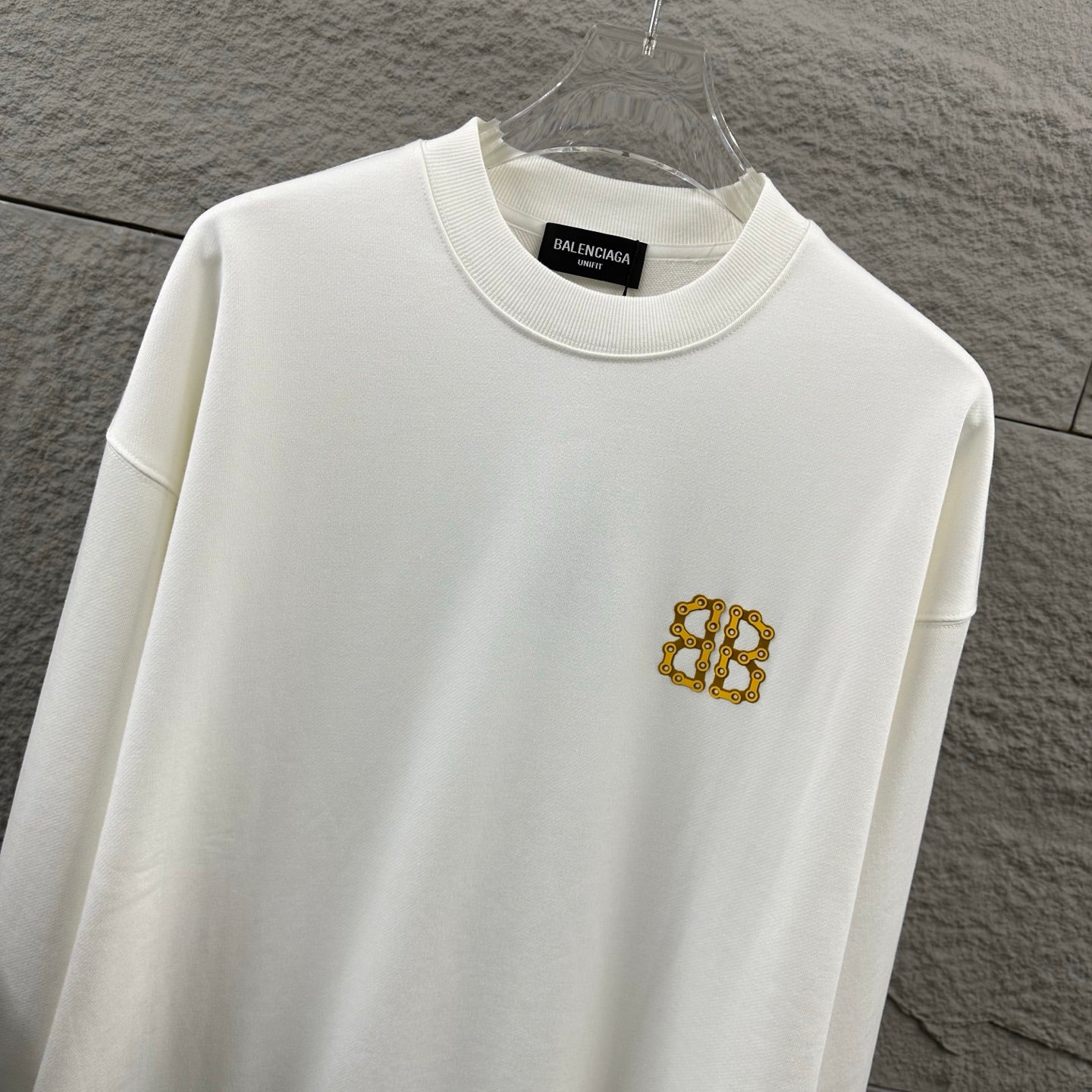 White crew-neck sweatshirt with gold Balenciaga monogram chest emblem