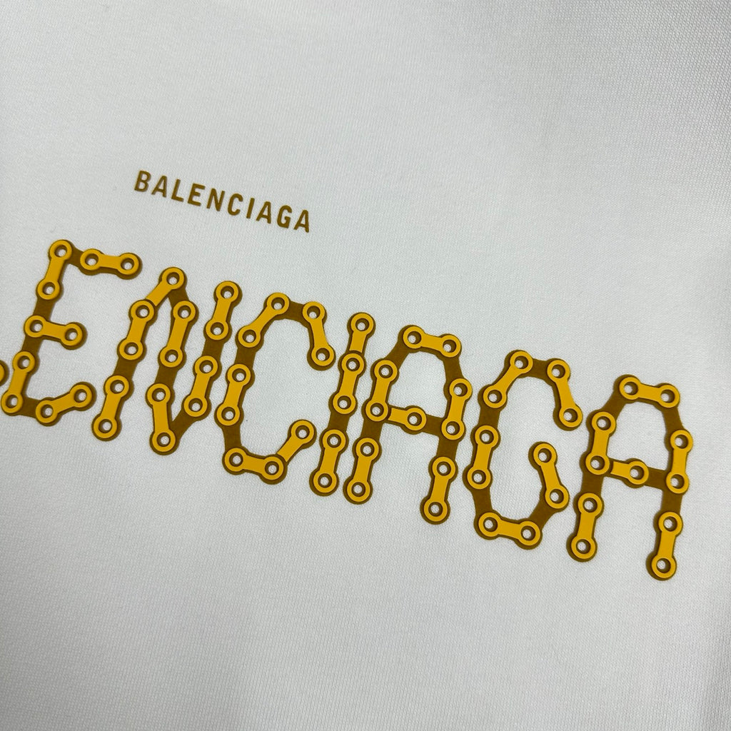 Close-up of gold Balenciaga lettering on a white sweatshirt front