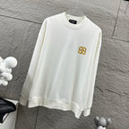 White crew-neck sweatshirt with gold monogram logo on the chest