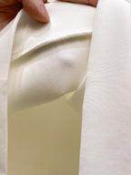 White crewneck sweatshirt fabric close-up with inner stitching detail.