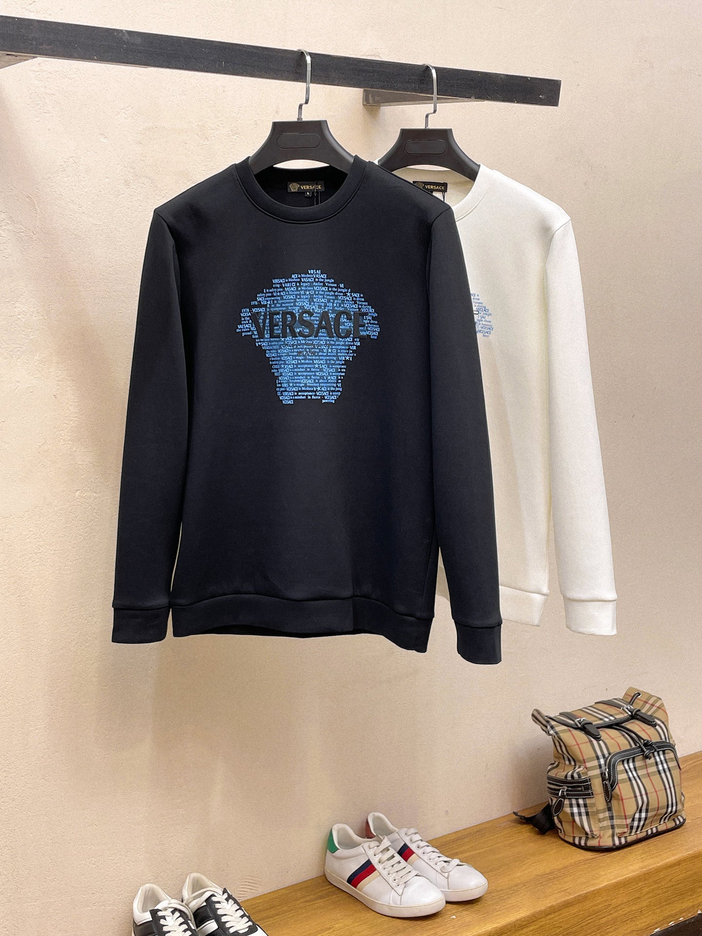 Crewneck sweatshirt pair: dark navy and white, both with blue Versace logo on chest.
