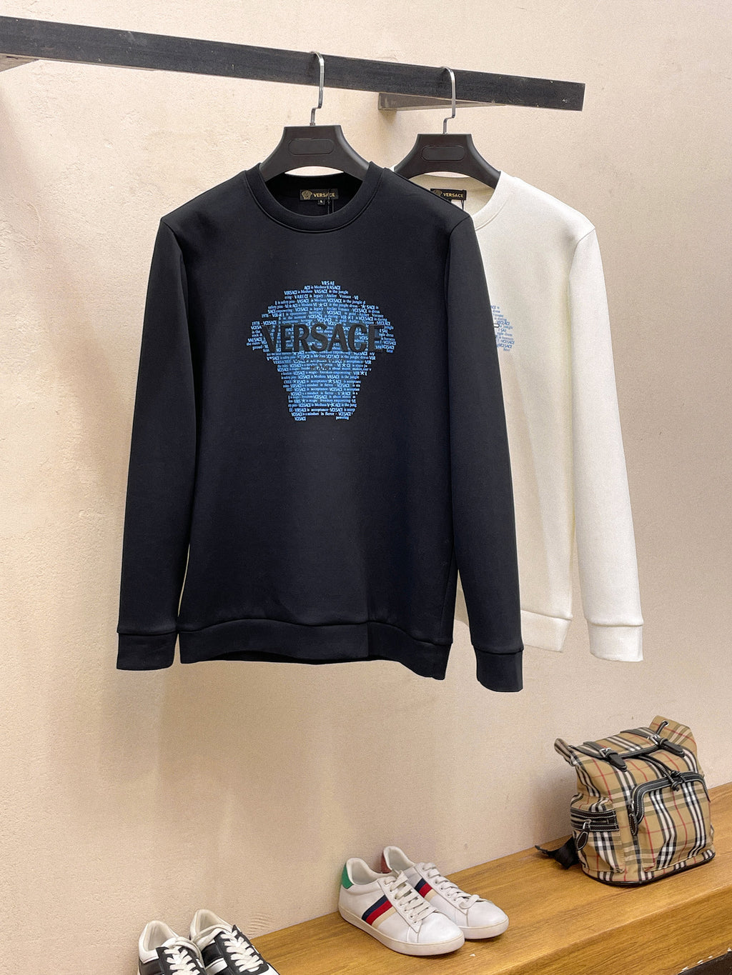Navy and white Versace sweatshirts hanging side by side