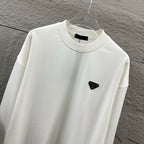 Off-white Prada sweatshirt close-up, crew neck and black triangular logo patch.