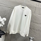 Off-white Prada sweatshirt with ribbed cuffs and black triangular logo patch.
