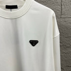 Off-white Prada crewneck sweatshirt with small black triangular logo patch.