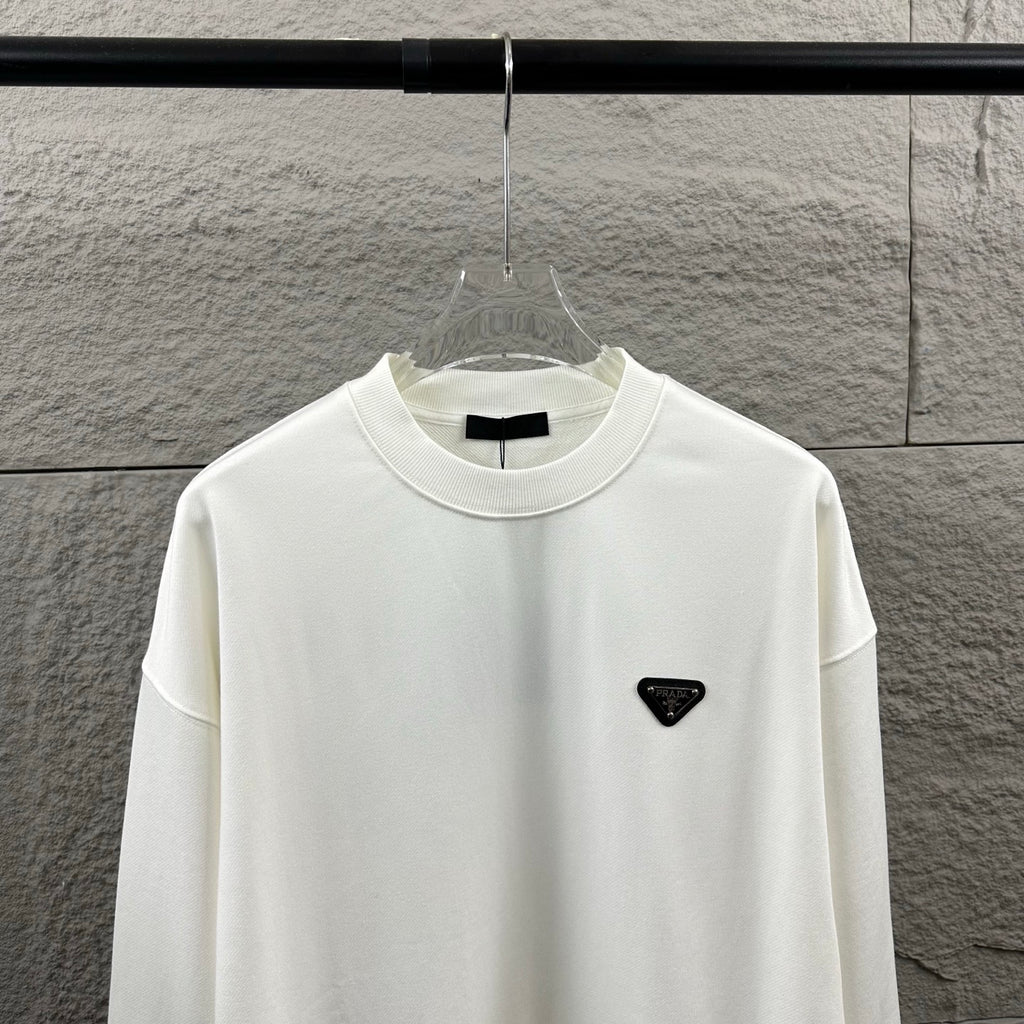 Off-white Prada crewneck sweatshirt with black triangular logo patch on chest.