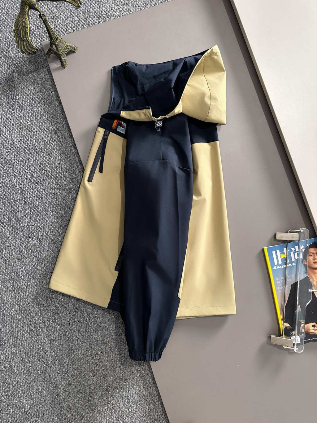Hooded windbreaker jacket back view in navy with light yellow panels and long sleeves