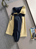 Hooded windbreaker jacket back view in navy with light yellow panels and long sleeves