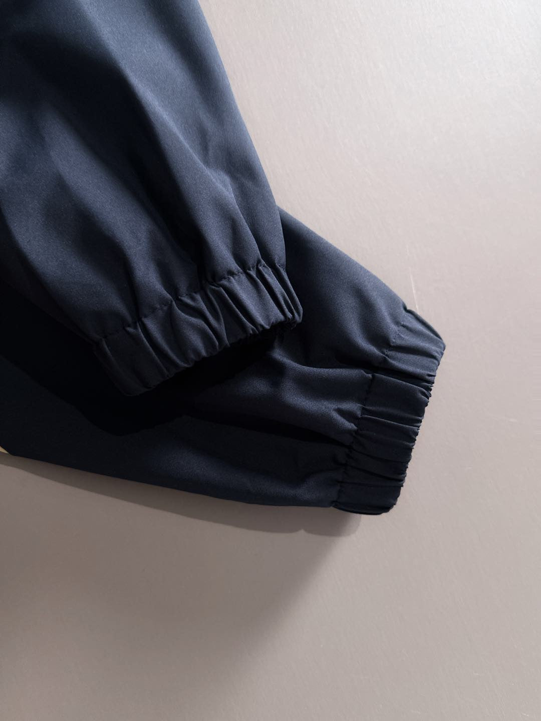 Navy windbreaker jacket with ruched elastic sleeve cuff