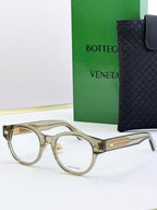 Bottega Veneta clear olive round eyeglasses with gold patterned temples and metal hinges