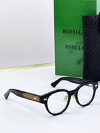 Bottega Veneta black angular eyeglasses with gold patterned temples and metal hinges