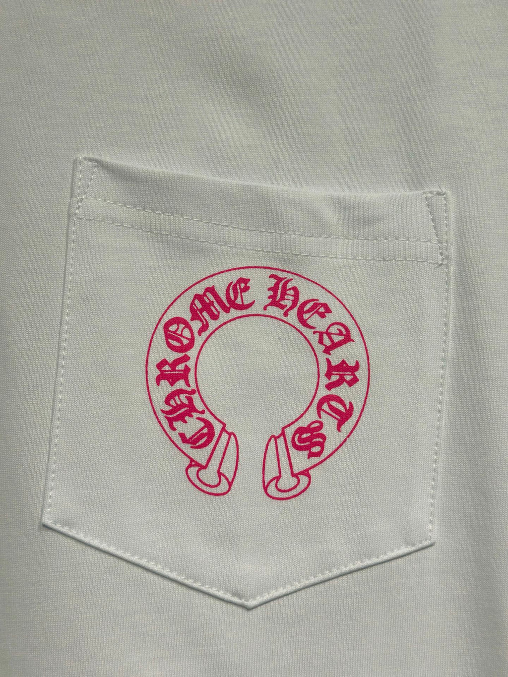 White long-sleeve T-shirt chest pocket with red-pink circular logo graphic.