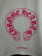 White long-sleeve T-shirt with red-pink circular logo print and small text below.