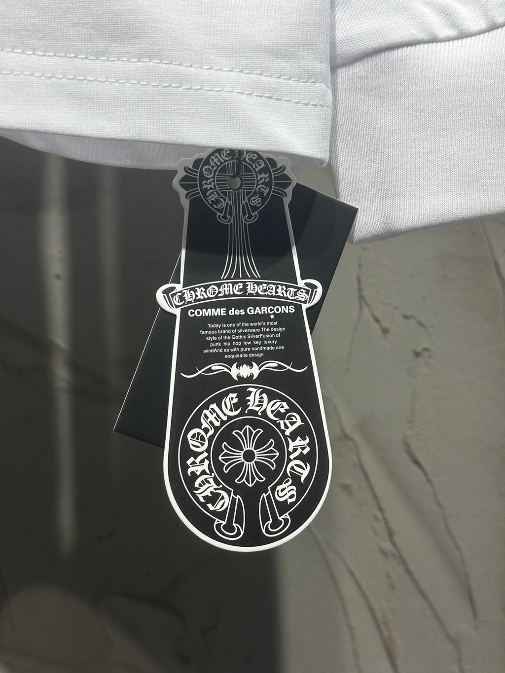 Long-sleeve T-shirt with neck label and brand hangtag attached.