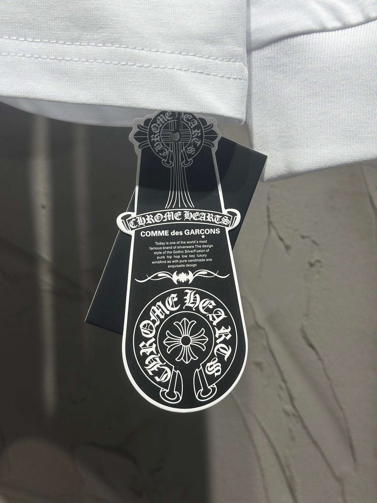 Long-sleeve T-shirt with neck label and brand hangtag attached.
