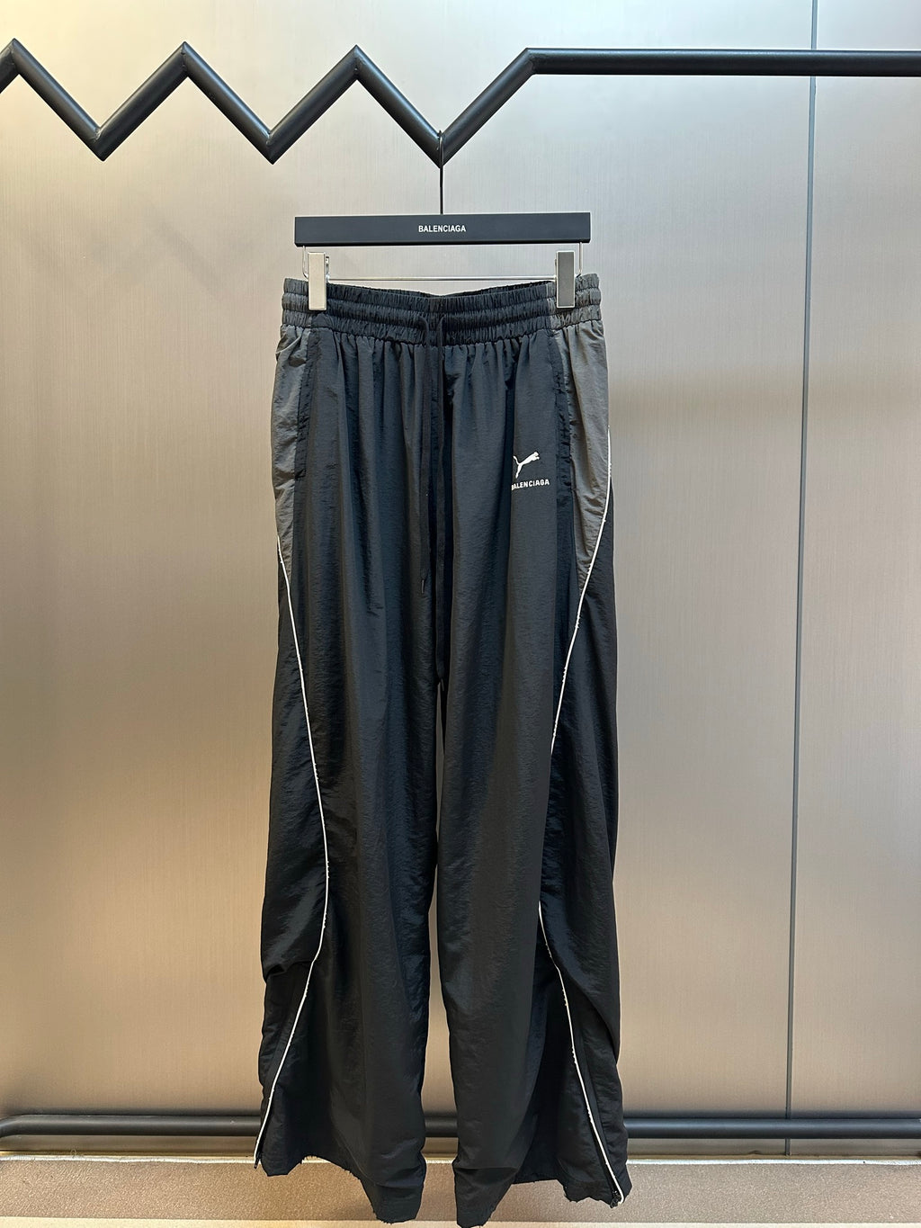 Dark navy drawstring pants with elastic waistband and logo print at thigh