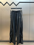 Dark navy drawstring pants with elastic waistband and logo print at thigh