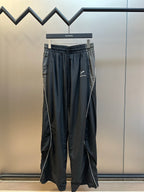 Dark navy drawstring pants with elastic waistband and logo print at thigh