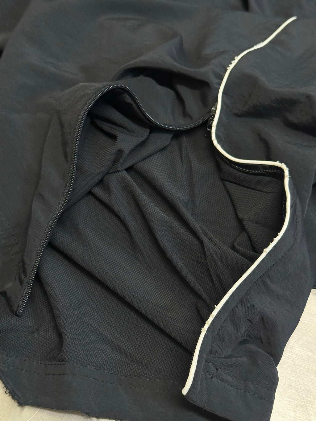 Dark navy pants with interior lining and contrast-trim piping along the edge