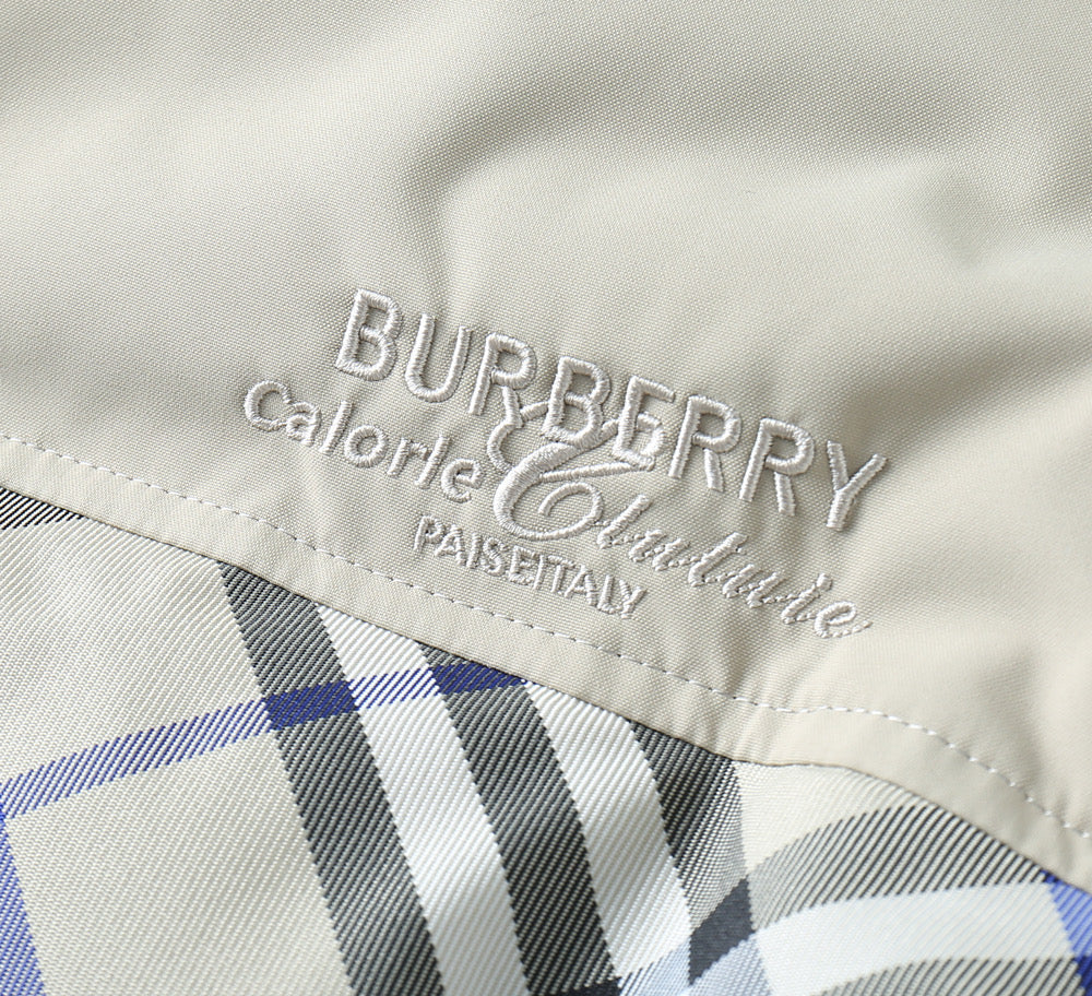 Burberry logo embroidery on jacket lining above a blue and black plaid section