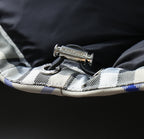 Burberry jacket interior trim with metal pull tag and stitched plaid edge