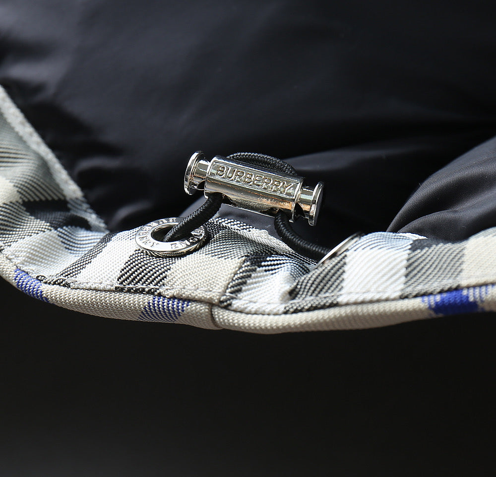 Burberry jacket interior trim with metal pull tag and stitched plaid edge