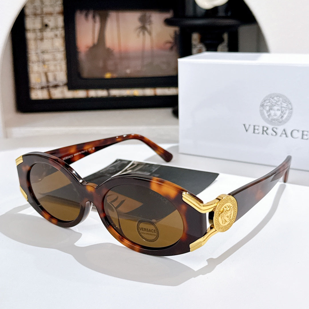 Versace sunglasses with dark lenses, tortoiseshell frame, and gold logo detail on the temple
