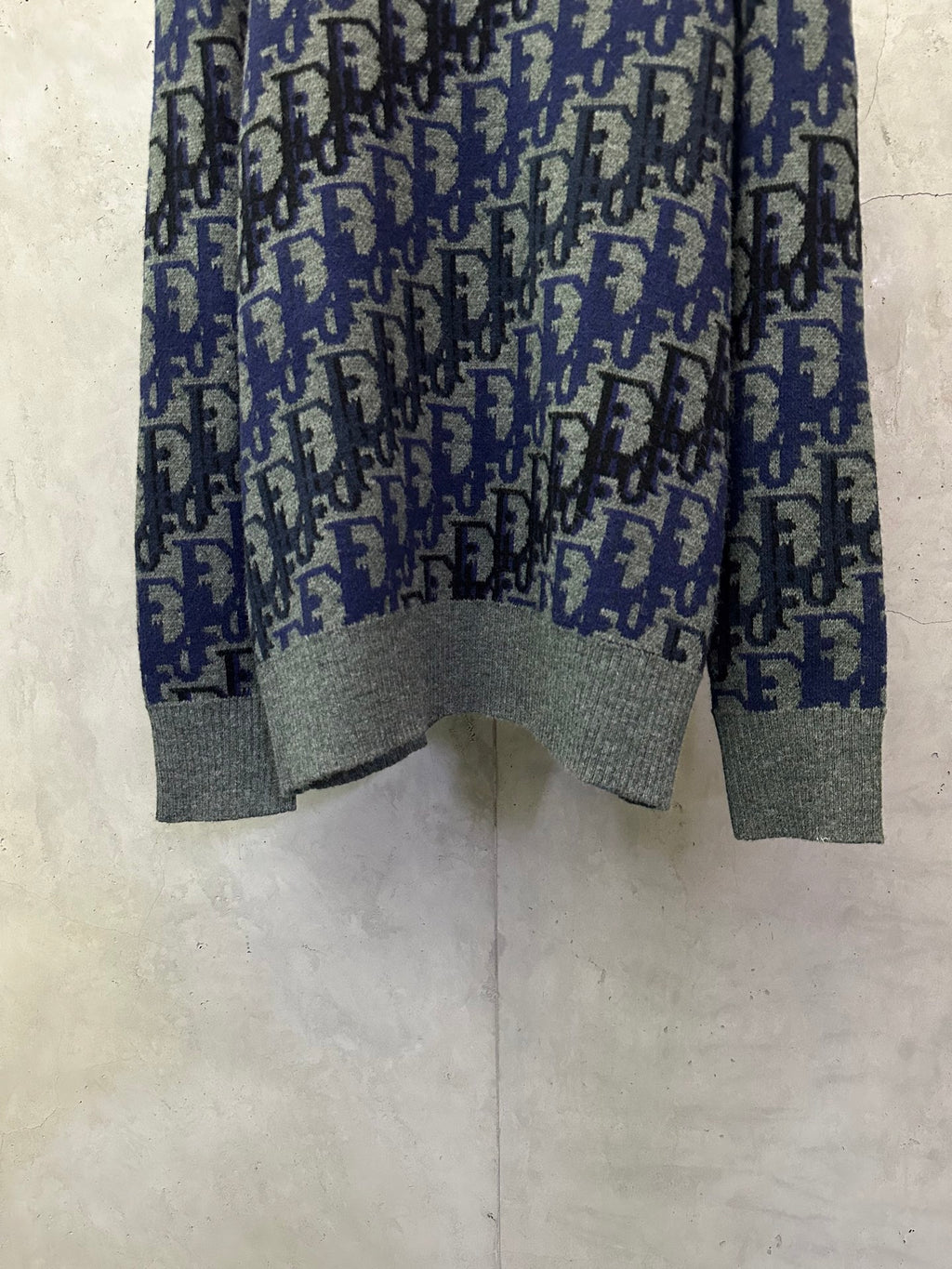 Dior long-sleeve knit sweater with blue-and-black logo pattern and gray bottom hem