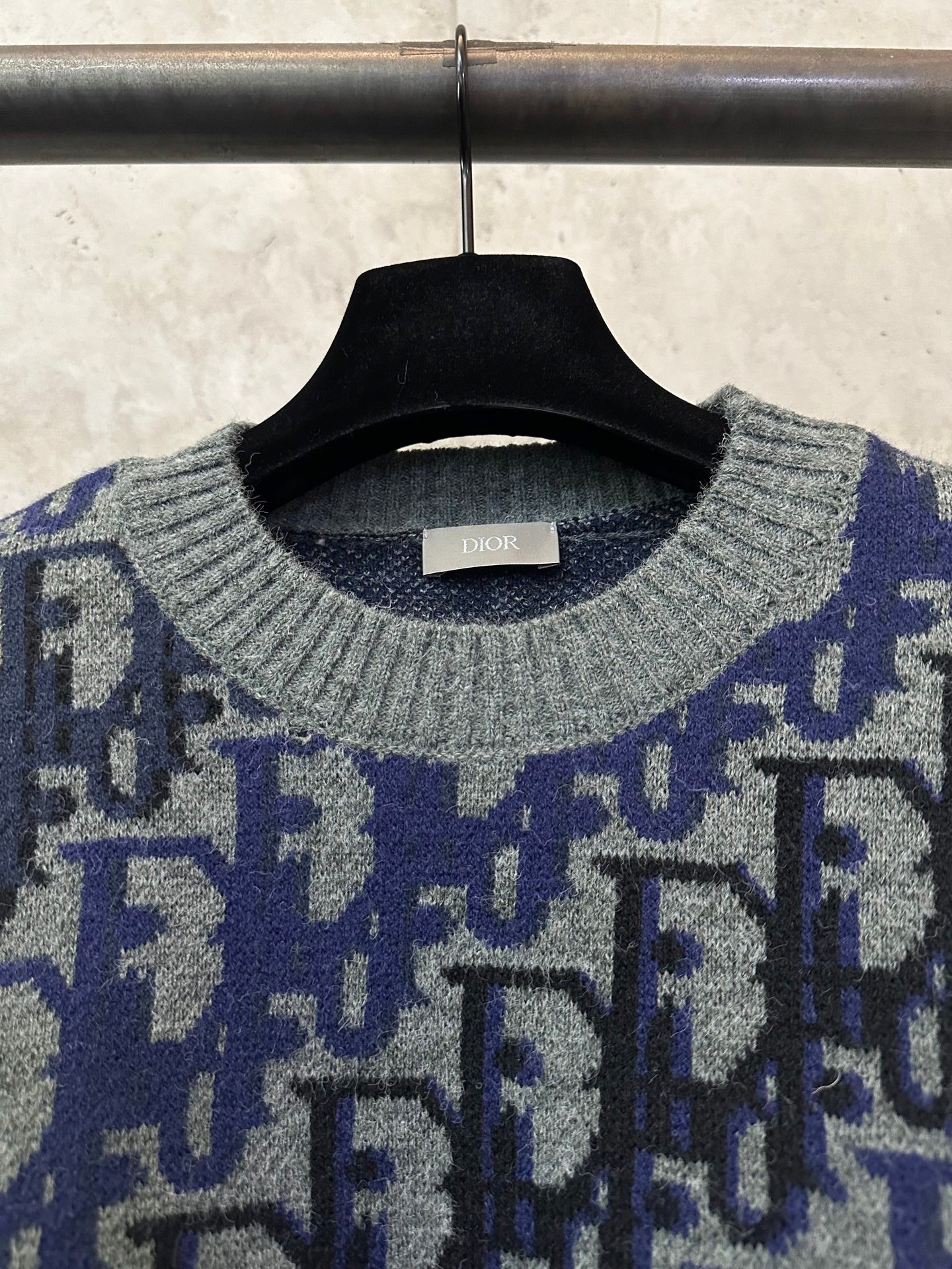 Dior knit sweater neckline close-up with gray ribbed collar and blue logo pattern