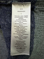Dior clothing care label on dark knit fabric, size L and material blend details