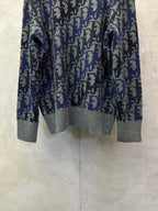 Dior knit sweater front view showing blue-and-black logo pattern and gray cuffs