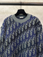Dior knit sweater close-up with blue and black logo pattern and ribbed collar