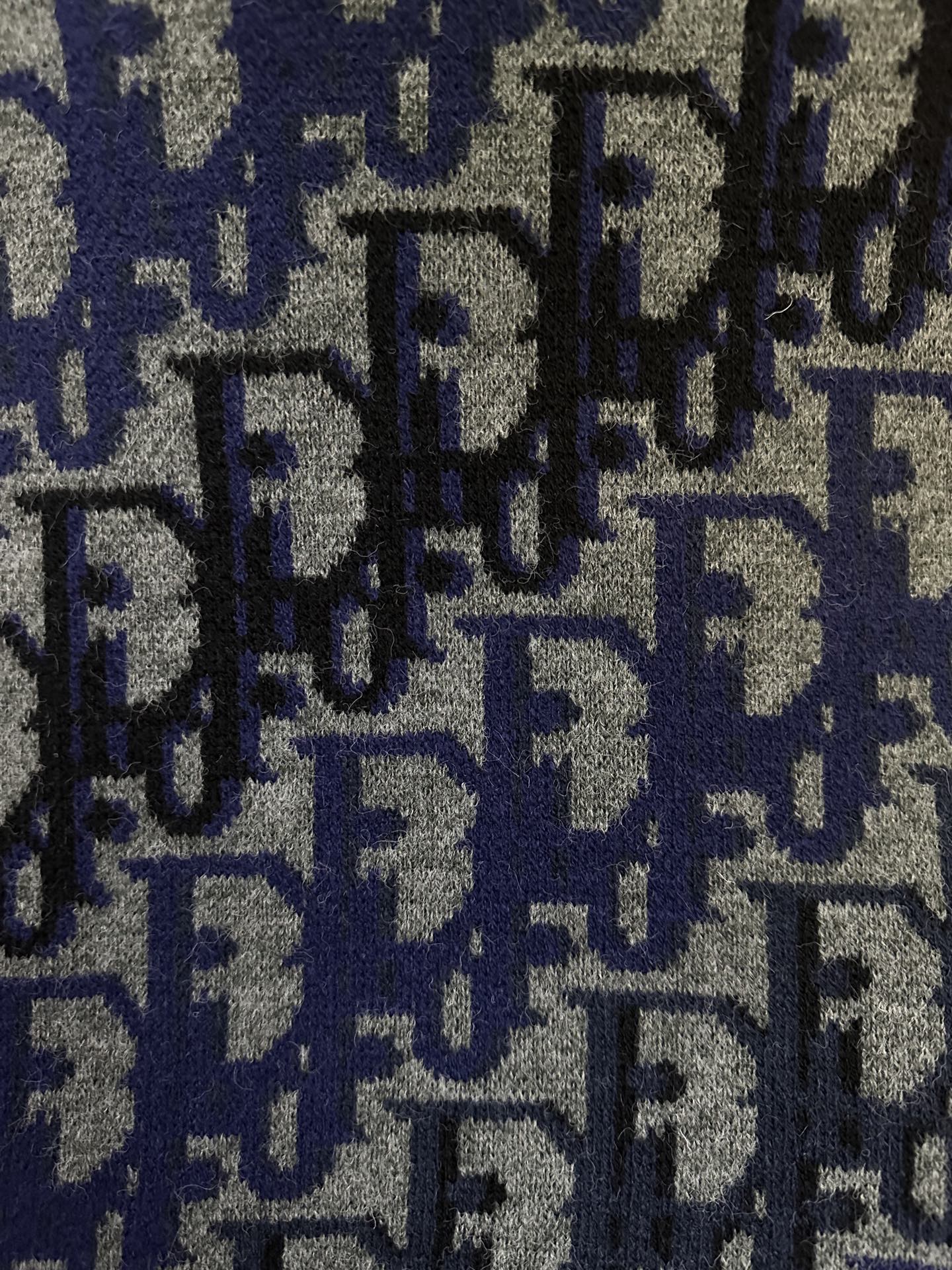 Dior knit fabric close-up with blue and black repeated logo pattern