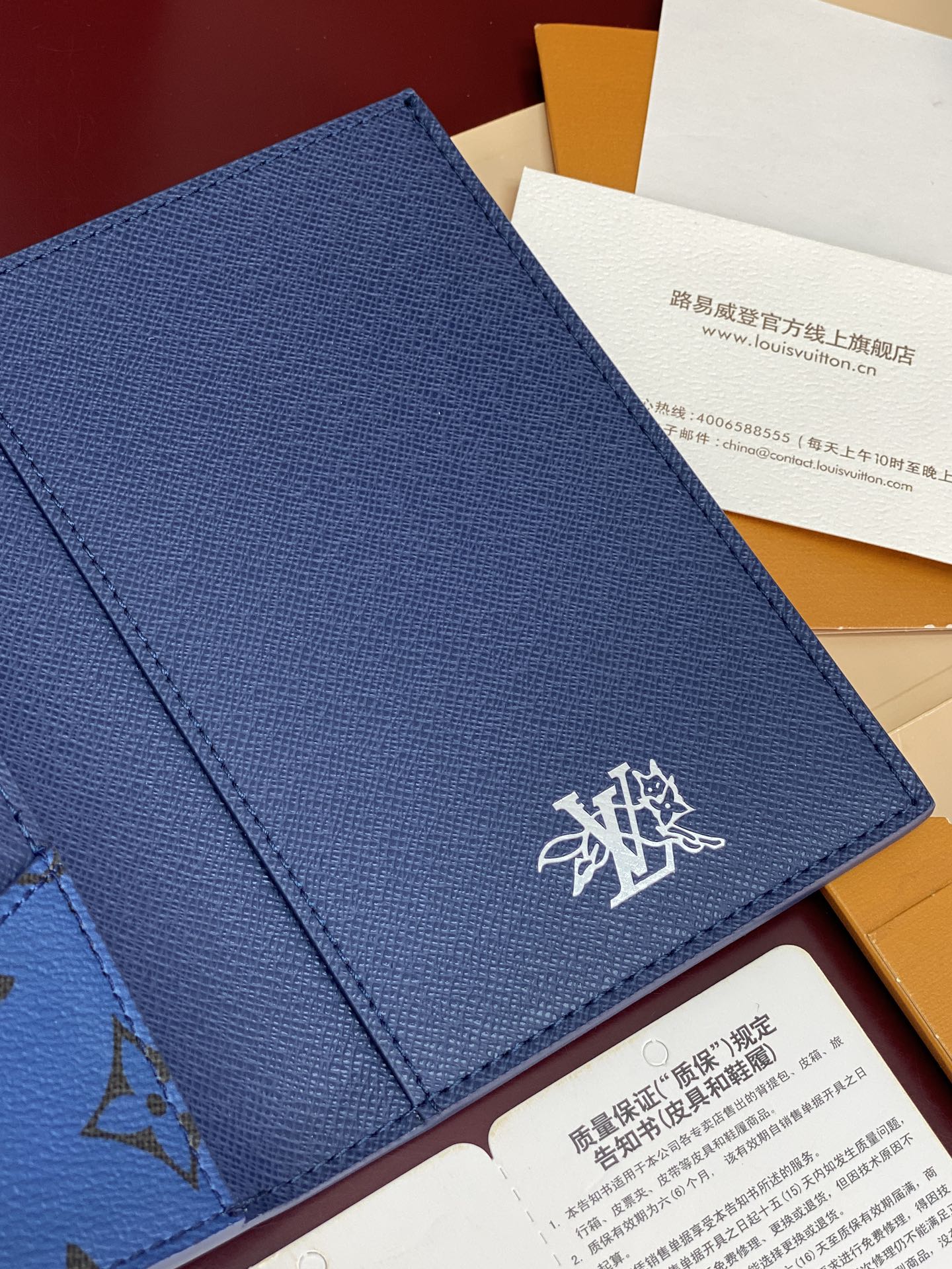 Blue Louis Vuitton wallet exterior with white emblem logo and stitching