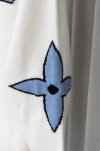 White sweater sleeve with blue emblem-style graphic