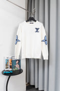 White long-sleeve sweater with blue logo graphic sleeves and crew neckline