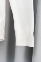 White sweater sleeve with ribbed cuff and knit texture
