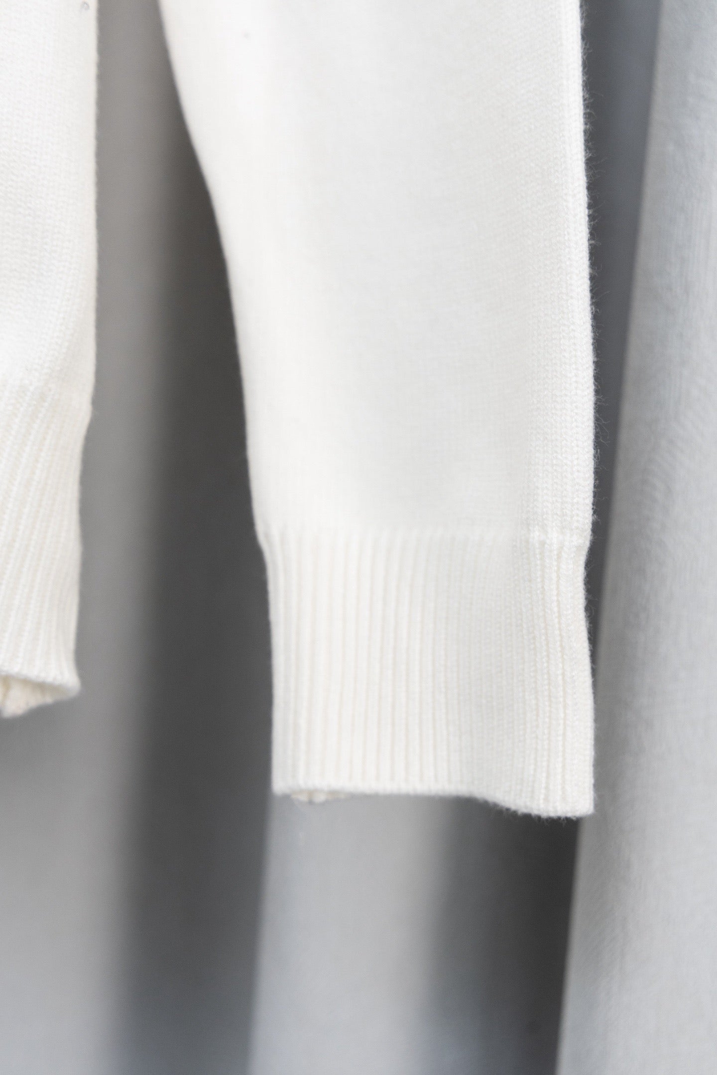 White sweater sleeve with ribbed cuff and knit texture