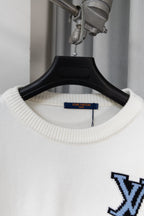 White crewneck sweater detail on hanger, blue logo graphic at chest