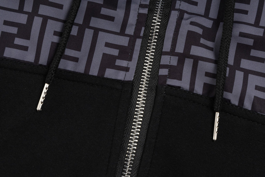 Black zip hoodie close-up with silver zipper pull and stitched seams