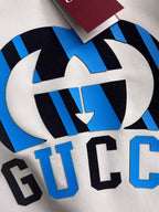 Close-up of blue-and-black graphic print and large “GUCC” lettering on sweatshirt