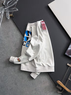White sweatshirt draped with partial blue-and-black logo print and neck tag