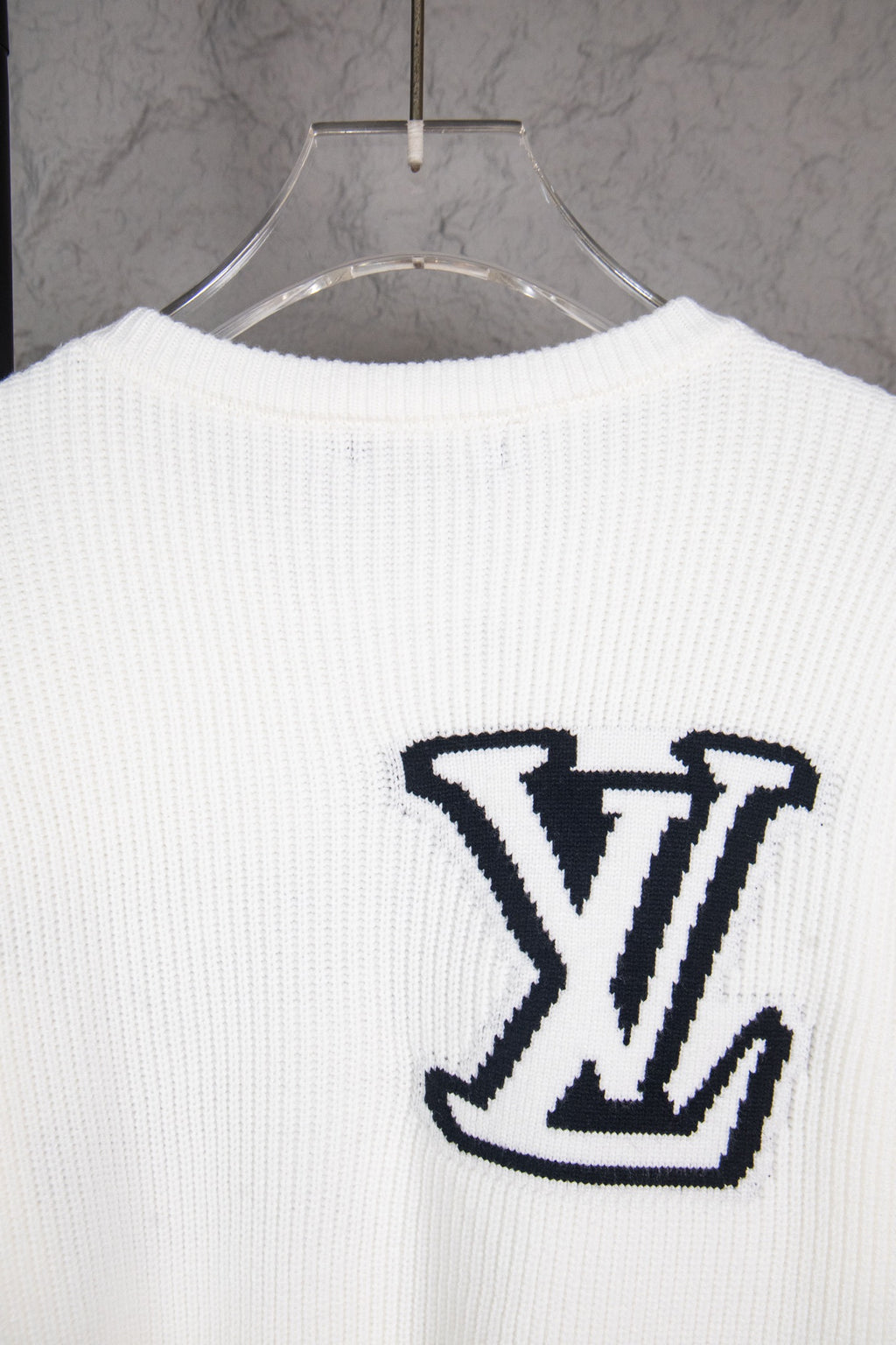 White long-sleeve knit sweater with centered navy LV logo on back