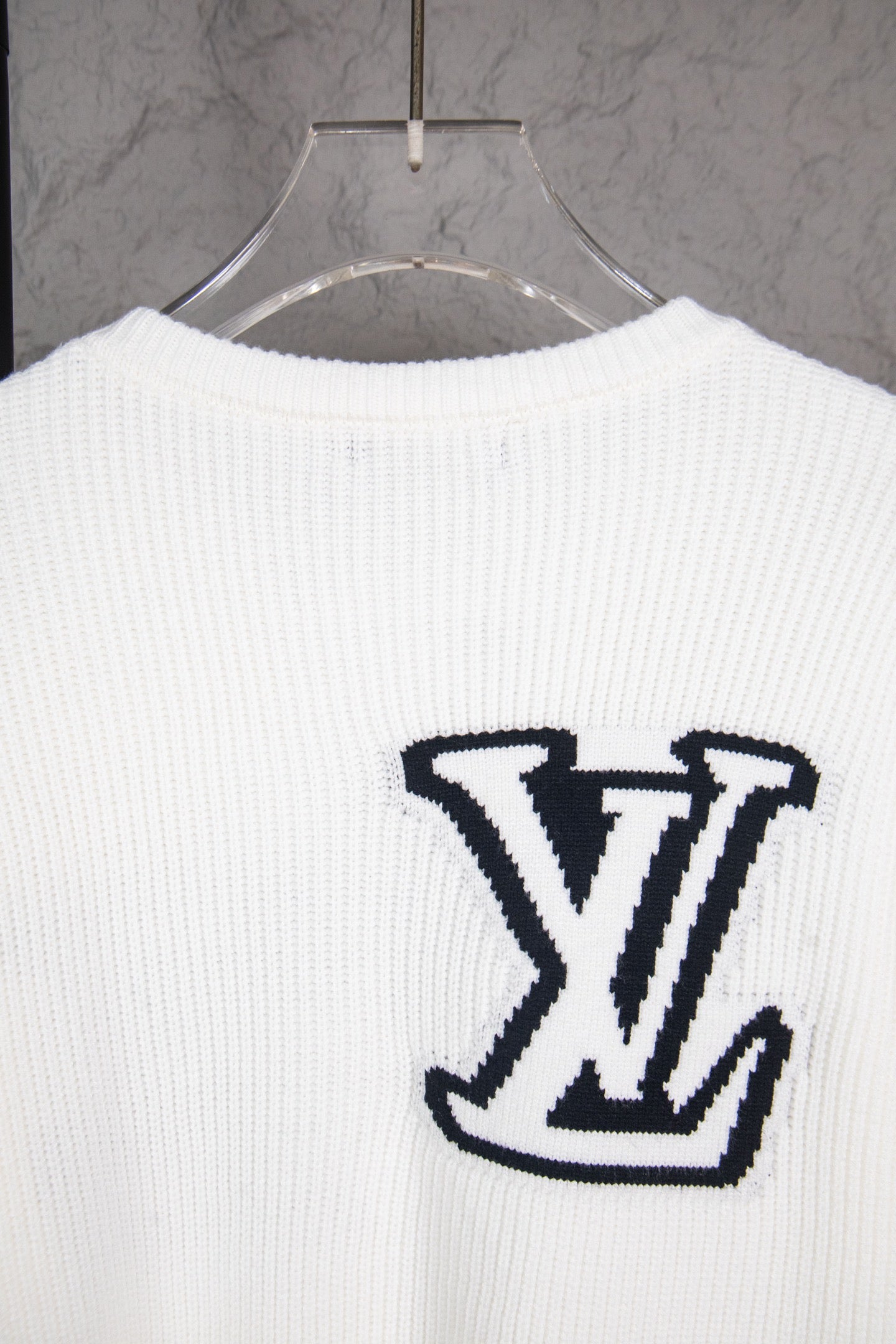 White long-sleeve knit sweater with centered navy LV logo on back