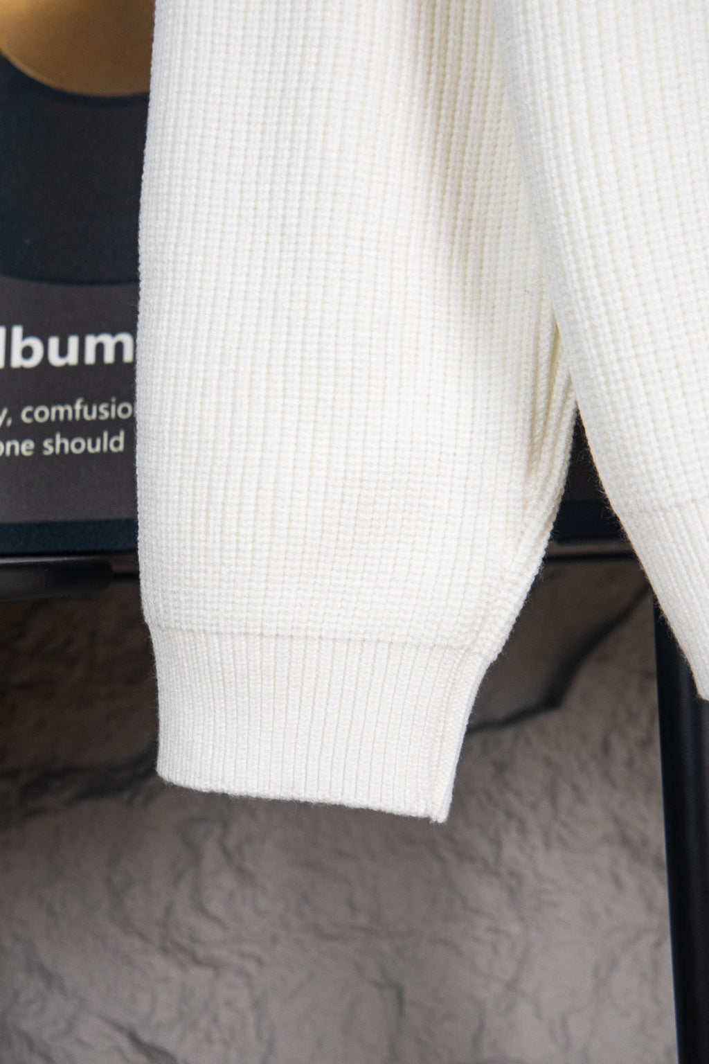 White knit sweater side with ribbed hem and cuff