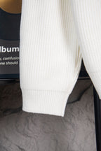 White knit sweater side with ribbed hem and cuff
